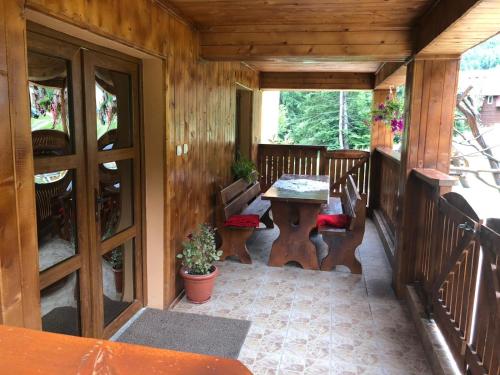 een veranda van een hut met een tafel en stoelen bij Cabana Cory Râușor in Rîu de Mori