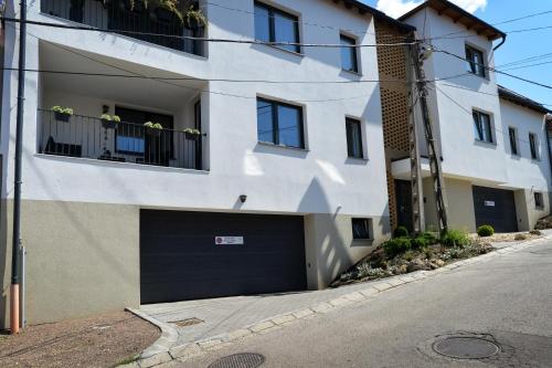 a white building with a garage door on a street at ONE Luxury Suites Eger in Eger