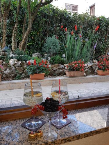 two wine glasses sitting on a table with flowers at Taverna coctel in Poreč
