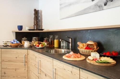 un bancone della cucina con lavandino e frutta e verdura di Midland a Sankt Anton am Arlberg