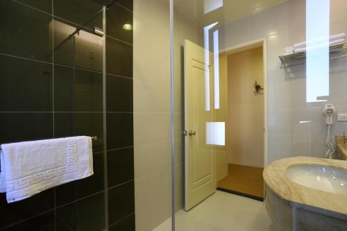 La salle de bains est pourvue d'un lavabo et d'une douche en verre. dans l'établissement Pulamayama, à Hualien