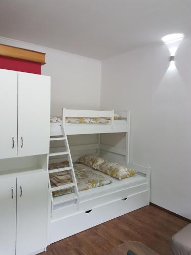 a white bunk bed with a ladder in a room at Apartma Opendoors Postaja in Most na Soči