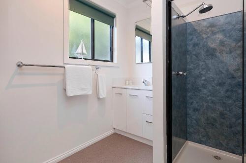 a bathroom with a shower and a sink at KINGFISHER COTTAGE Beachfront at the Binalong Bay in Binalong Bay