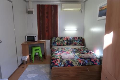 a small room with a couch and a green stool at Mud Crab Motel in Derby