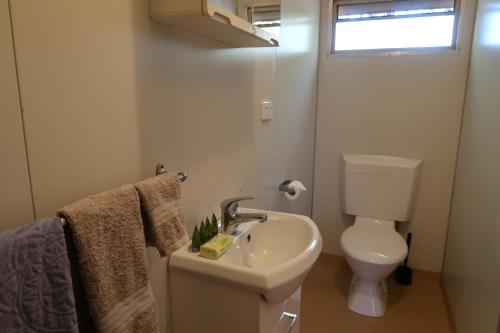 ein weißes Bad mit einem WC und einem Waschbecken in der Unterkunft Mud Crab Motel in Derby