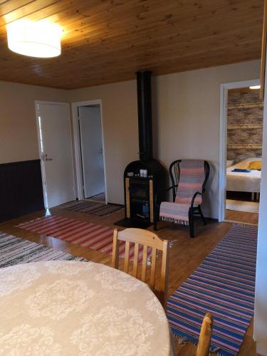 ein Wohnzimmer mit Holzofen und einem Bett in der Unterkunft Tontti in Petääjärvi