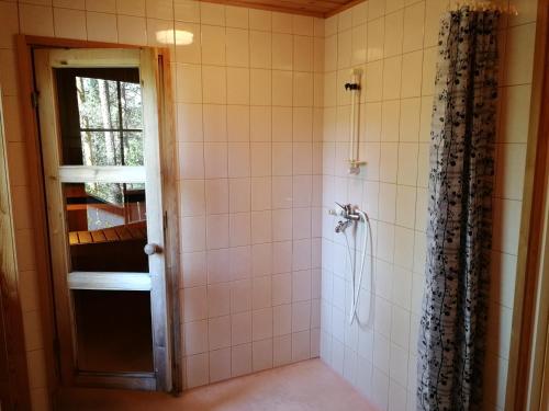 ein Badezimmer mit Dusche mit Glastür in der Unterkunft Tontti in Petääjärvi