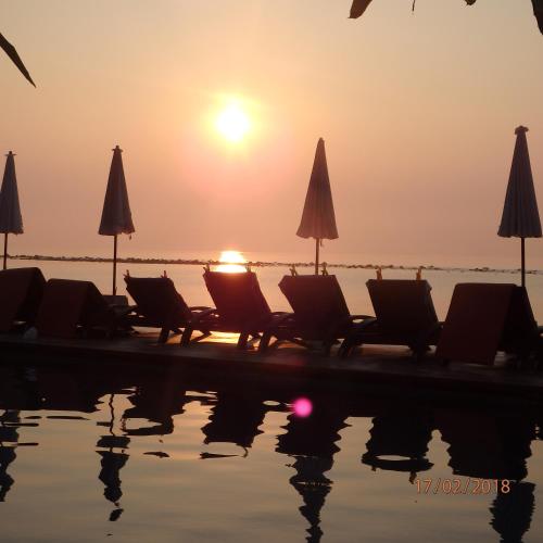 a group of chairs and umbrellas next to a pool at Montien House - SHA Plus in Chaweng