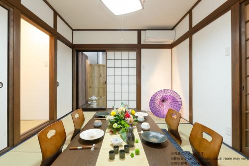 a dining room with a wooden table and chairs at Stay SAKURA Kyoto Toji Machiya in Kyoto