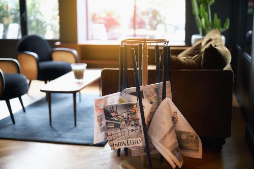 a vase sitting on top of a table with magazines at Hotel Victoria in Valence