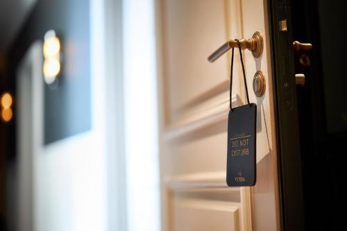 a door tag hanging from a door knob at Hotel Victoria in Valence