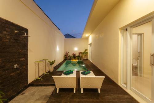a pool in the middle of a room with a table and chairs at Villa Julie & Villa Sydney, Seminyak - 2 Bedroom Modern Pool Villas! in Seminyak