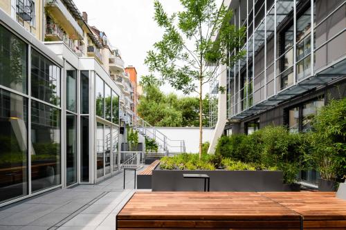 a courtyard in an office building with a wooden bench at Mercure München City Schwabing in Munich
