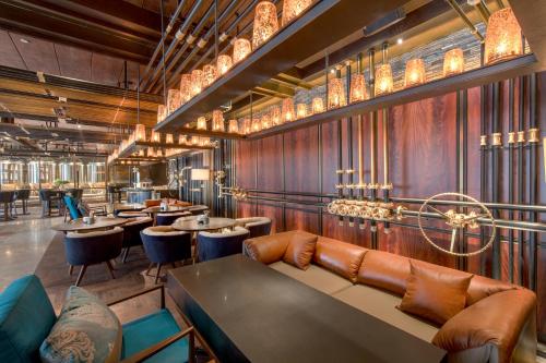 a restaurant with tables and couches and chandeliers at Midtown Shangri-La, Hangzhou - around 5 minutes walking distance to West Lake in Hangzhou