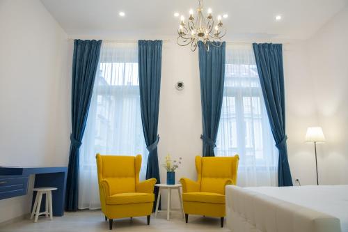 a bedroom with two yellow chairs and a bed at SUNNY NOVEMBER in Braşov