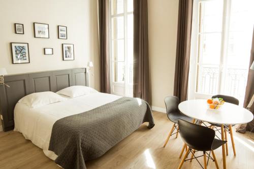 a bedroom with a bed and a table and chairs at Maison Dormoy in Marseille
