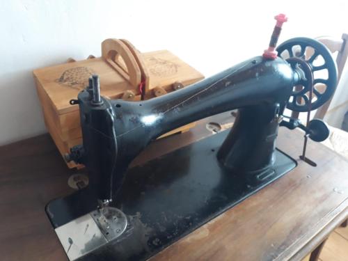a black sewing machine sitting on top of a table at Casa museo "Sa domu de ziu Antoneddu" in Tuili