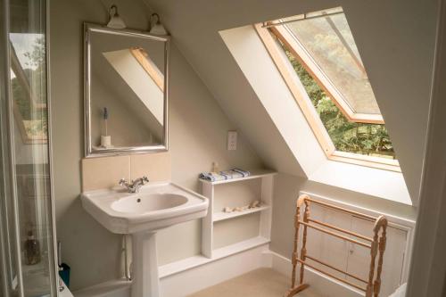 La salle de bains est pourvue d'un lavabo, d'un miroir et d'une fenêtre. dans l'établissement The Old Dairy (Chute Forest), à Andover