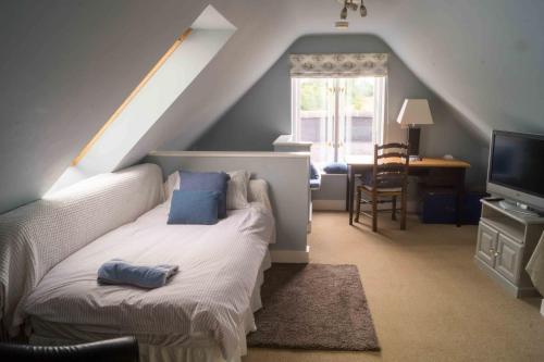 1 dormitorio con cama, escritorio y ventana en The Old Dairy (Chute Forest), en Andover