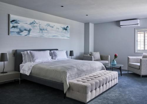 a bedroom with a large bed and two chairs at Kianga in Gordonʼs Bay