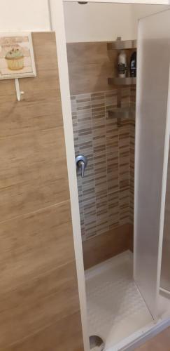 La salle de bains est pourvue d'une douche et de parquet. dans l'établissement dammuso veranda vista mare, à Pantelleria
