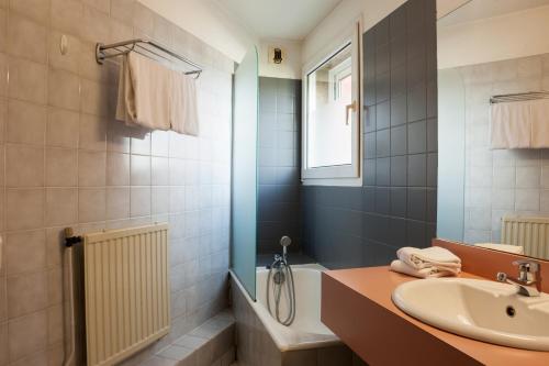 La salle de bains est pourvue d'un lavabo, de toilettes et d'une baignoire. dans l'établissement Kyriad Direct Rennes Ouest, à Vezin-le-Coquet