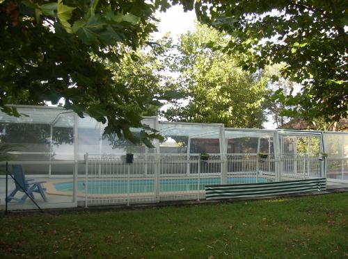 - une piscine dans une maison en verre avec une piscine dans l'établissement Gite piscine au sel, à Castillonnès