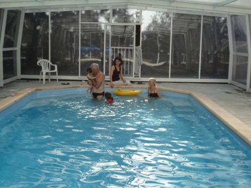 un groupe d'enfants jouant dans une piscine dans l'établissement Gite piscine au sel, à Castillonnès