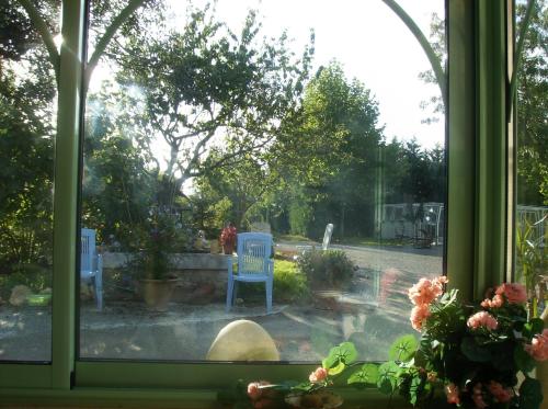 una ventana con vistas a un patio con 2 sillas azules en la piscine relaxe en Castillonnès