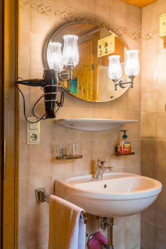 a bathroom with a sink and a mirror at Am Ferienbauernhof Schmiedbauer com Salzkammergut in Faistenau