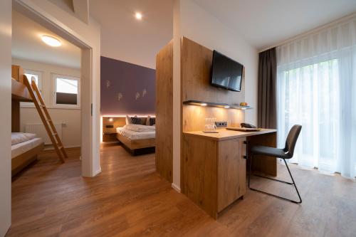 a hotel room with a desk and a bedroom at Pflugwirts Hotel und Gasthaus in Oberkirch