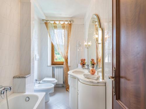 a white bathroom with a sink and a toilet at La Pergola in Monticiano