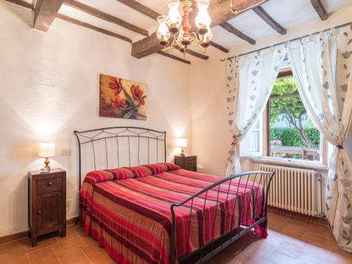 a bedroom with a bed and a window at La Pergola in Monticiano