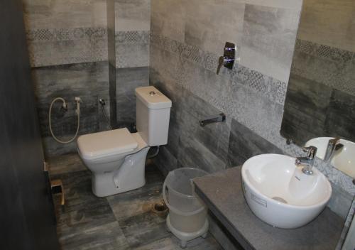 ein Bad mit einem WC und einem Waschbecken in der Unterkunft HOTEL SHIVAYE in Haridwar