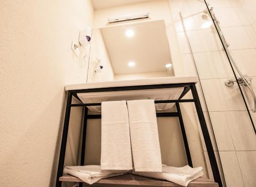 a bathroom with a towel rack and a sink at A&M Hotel with free parking in Plovdiv