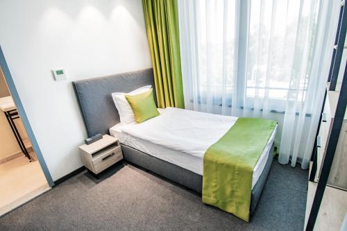 a small room with a bed and a window at A&M Hotel with free parking in Plovdiv