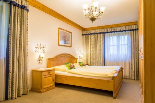 a bedroom with a bed and a chandelier at Am Ferienbauernhof Schmiedbauer com Salzkammergut in Faistenau