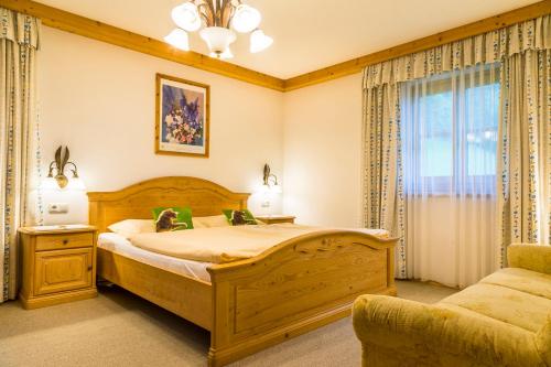 a bedroom with a large bed and a couch at Am Ferienbauernhof Schmiedbauer com Salzkammergut in Faistenau