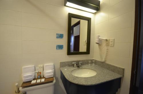 a bathroom with a sink and a mirror at Microtel by Wyndham Puerto Princesa in Puerto Princesa City