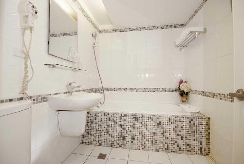 a bathroom with a tub and a sink and a toilet at The Metro Hotel - Taipei Branch in Taipei