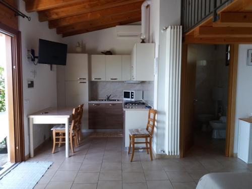 - une cuisine avec une table et des chaises dans la chambre dans l'établissement B&B Camister, à Toscolano Maderno