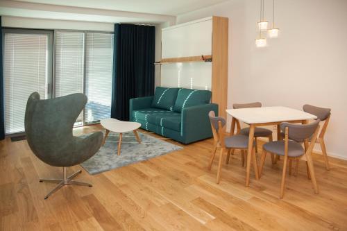 ein Wohnzimmer mit einem Tisch und einem grünen Sofa in der Unterkunft Riverside Apartment in Pärnu