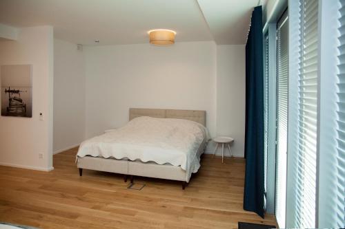 Schlafzimmer mit einem Bett und Holzboden in der Unterkunft Riverside Apartment in Pärnu