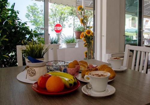 a table with plates of food and cups of coffee at Hotel Everest - Bar e Ristorante in Gabicce Mare