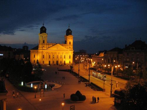 a building at night with people walking in front of it at Visit Debrecen Apartman in Debrecen