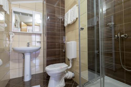 a bathroom with a toilet and a sink and a shower at Hotel Adria in Neum