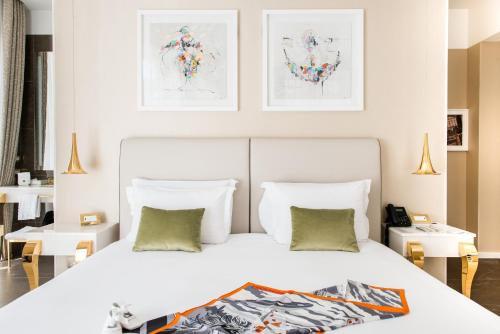 a bedroom with a large white bed and two tables at Boscolo Lyon Hotel & Spa in Lyon