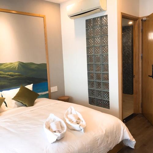 a bedroom with a bed with white towels on it at Banana Flower Homestay in Da Nang