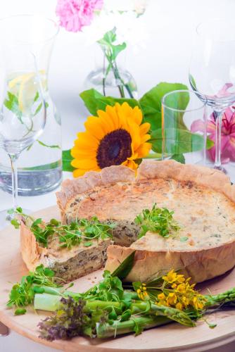 a sandwich on a plate on a table with flowers at Hotel Kazimierzówka in Kazimierz Dolny