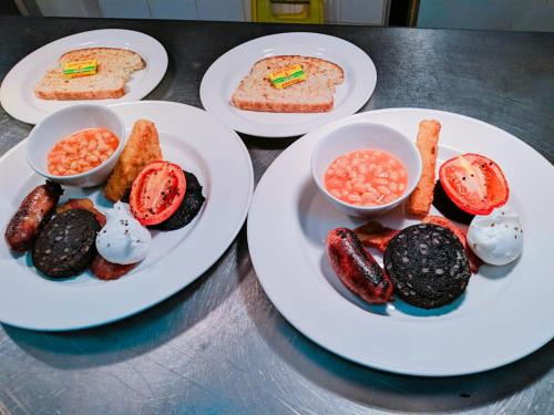 Una mesa con tres platos de comida encima. en Chequers Inn, en Fladbury